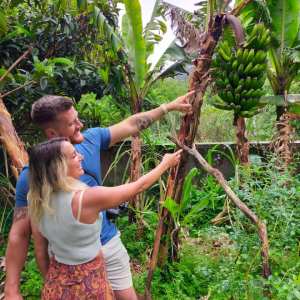 a young girl standing next to a tree