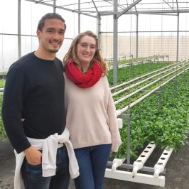 a man and a woman standing in front of a fence