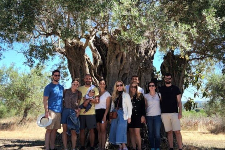 a group of people standing in front of a tree