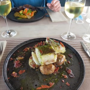 a person sitting at a table with a plate of food