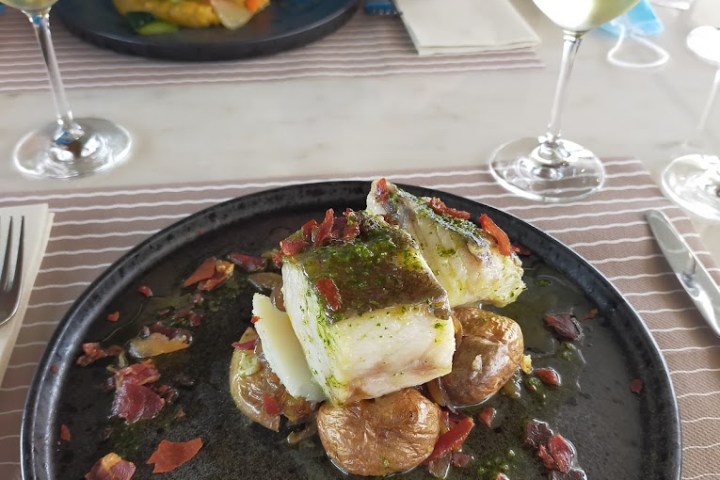 a person sitting at a table with a plate of food