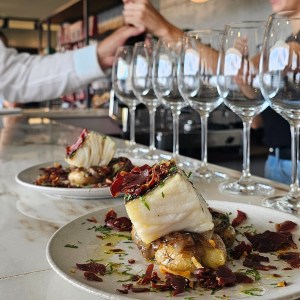 a plate of food and glasses of wine on a table