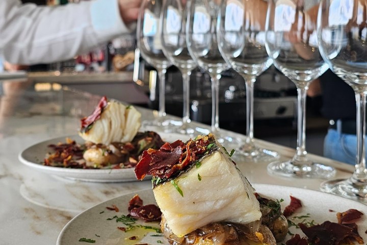 a plate of food and glasses of wine on a table