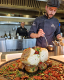 a person cutting a pizza on a table