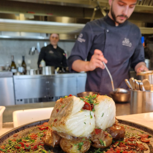 a person cutting a pizza on a table