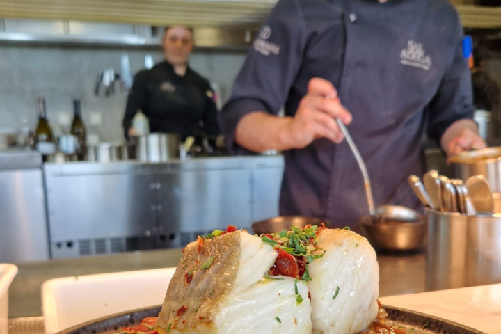 a person cutting a pizza on a table
