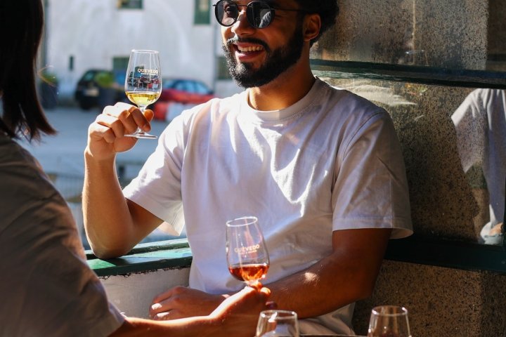 a person holding a glass of beer on a table