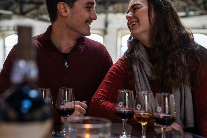 a man sitting at a table with wine glasses