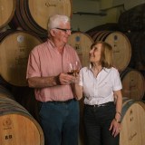 a man and a woman standing in front of a barrel