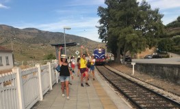 People walking on a train platform near tracks; train approaching.