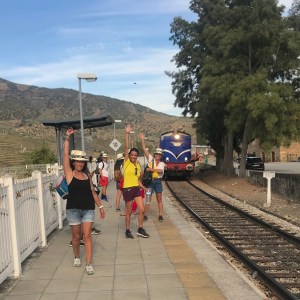 People walking on a train platform near tracks; train approaching.