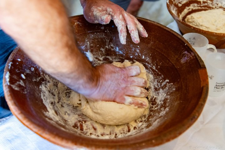 Hands kneading traditional bread dough in a clay bowl, Algarve