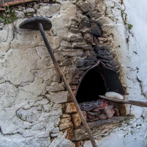 Traditional stone wood-fired oven burning with firewood in the Algarve