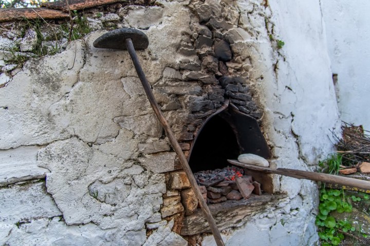 Traditional stone wood-fired oven burning with firewood in the Algarve
