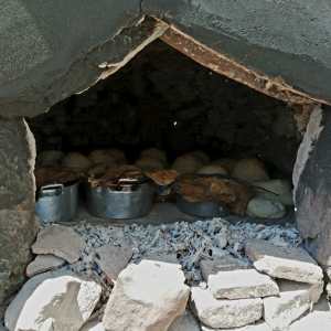 Traditional stone wood-fired oven burning with firewood in the Algarve