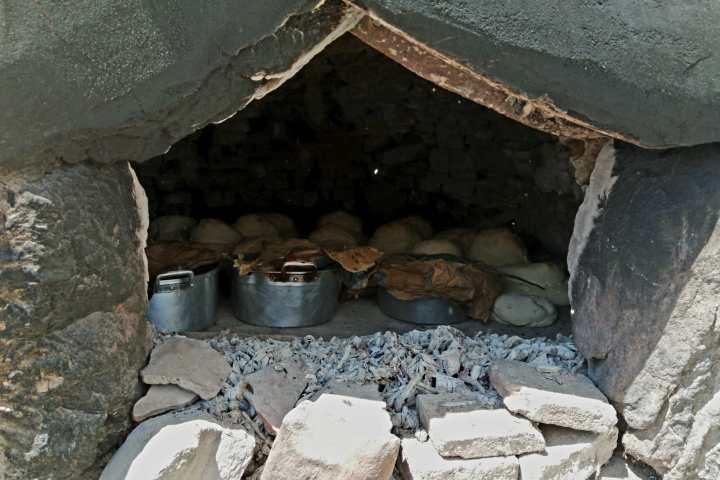 Traditional stone wood-fired oven burning with firewood in the Algarve