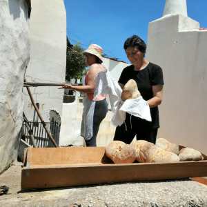 Shaping bread dough by hand before baking in a wood-fired oven