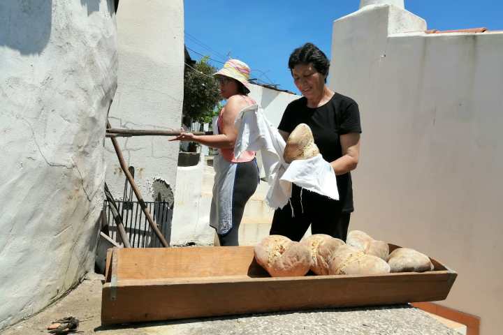 Shaping bread dough by hand before baking in a wood-fired oven