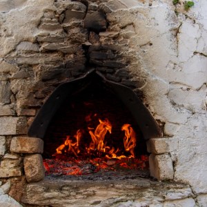 Stone oven with visible fire and embers.
