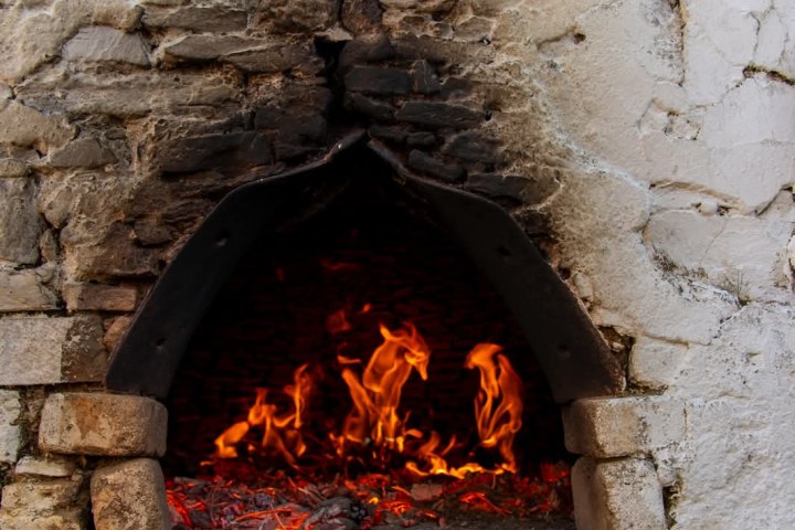 Stone oven with visible fire and embers.
