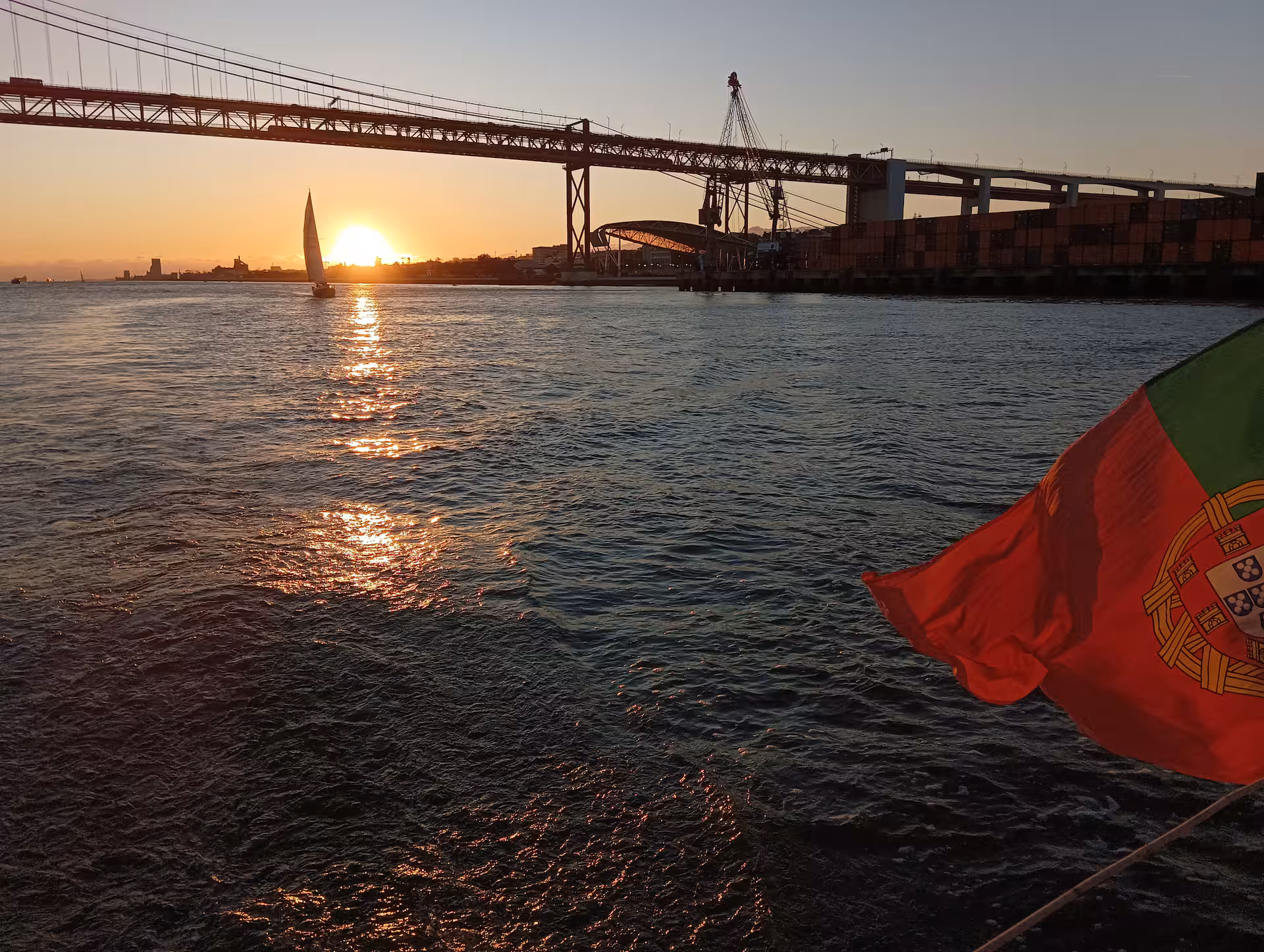 View of Cristo Rei and Ponte 25 de Abril from a private sailboat on the Tagus River in Lisbon