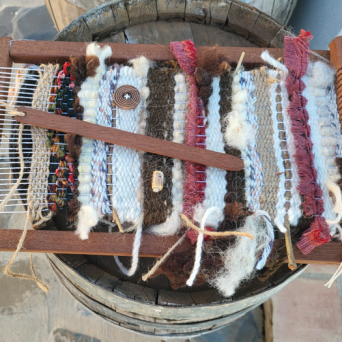 Close-up of a handwoven piece in progress on a wooden loom