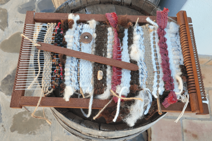 Close-up of a handwoven piece in progress on a wooden loom