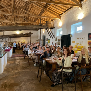 A large group of people seated at tables in a rustic restaurant.