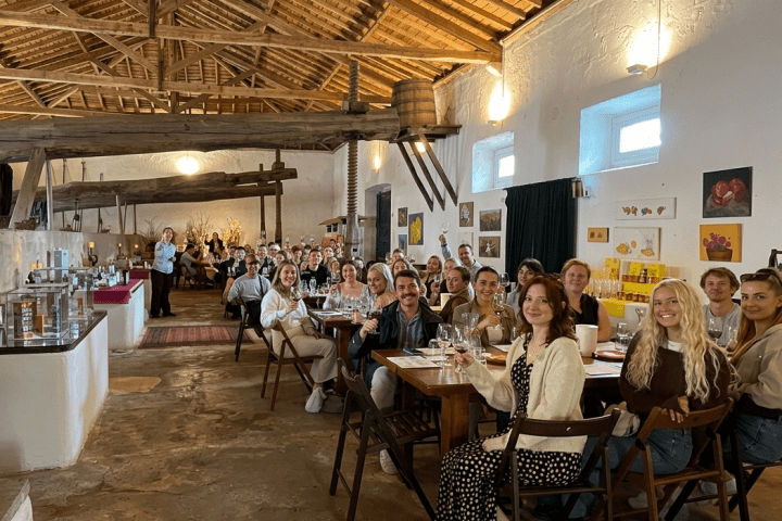 A large group of people seated at tables in a rustic restaurant.