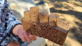 Person holding wooden block with attached corks.