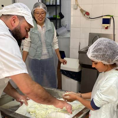 Cheesemaker guiding a family through traditional cheese making in Portugal