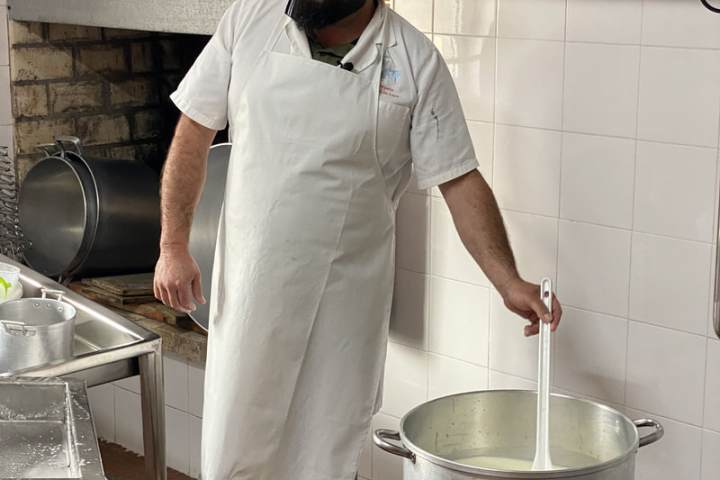 Cheesemaker heating sheep's milk in the dairy before cheese making